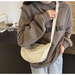 Detail of off-white crescent crossbody bag with adjustable strap and logo on canvas