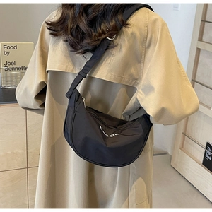 Close-up of black nylon crescent crossbody bag with white BOU GU embroidery