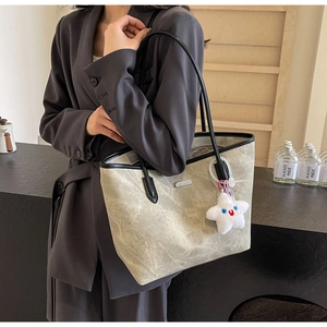 Détail du sac cabas vert clair avec anses noires et un charmant pendentif étoile