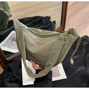 Detail of olive green nylon crescent bag with Dou Gu logo and silver zipper
