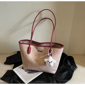 Détail du cabas MESSERTI en daim beige avec bordure bordeaux et breloque étoile