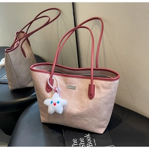 Détail du grand sac cabas avec poignées en cuir rouge et pendentif étoile en peluche