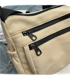 Detail of high-quality nylon crossbody bag showing smooth double zippers and twill fabric