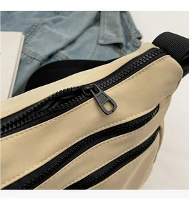 Detail view of durable nylon fabric and three parallel smooth black zippers on a beige bag