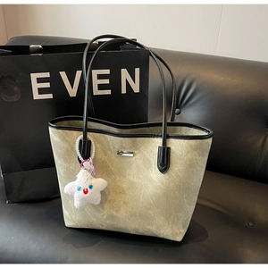 Détail d'un grand sac cabas avec logo métallique et pendentif étoile en peluche