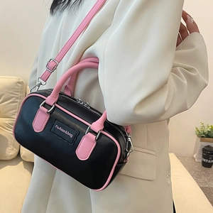 Chic black and pink contrast leather bowling bag with top handles and adjustable strap