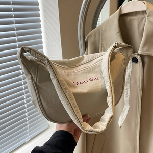 Large beige nylon dumpling crossbody bag with red Dou Gu lettering and wide strap