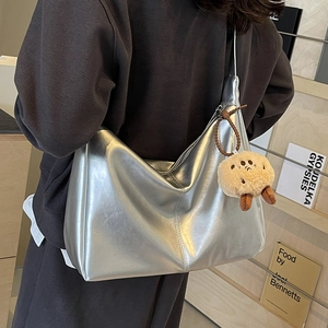 Silberne Tote Bag in Metallic-Optik mit strukturiertem Finish und süßem Plüsch-Anhänger