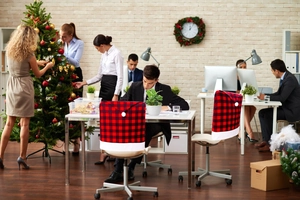 Detail of red and black buffalo plaid Christmas hat chair cover with white plush pompom