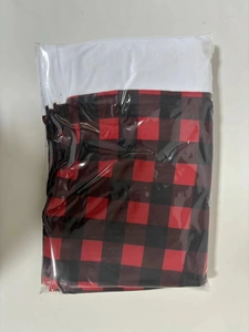 Detail of buffalo plaid Christmas chair cover with white plush trim in packaging