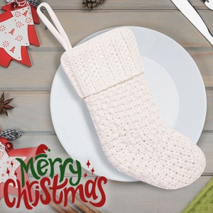 Detail of ivory cable knit Christmas stocking with textured patterns for mantel decoration