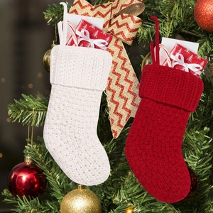 Classic red and white cable knit Christmas stockings set hanging on a festive Xmas tree