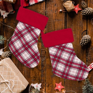 Detail of red checkered Christmas stockings on rustic wood with festive decor
