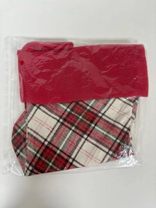 Detail of red plaid Christmas stocking with soft plush cuff in transparent packaging