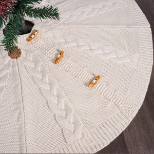 Macro detail of cream cable knit Christmas tree skirt with wooden buttons on wood floor
