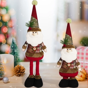Close-up of handmade Santa Claus plush dolls with plaid coats and long hats in festive setting