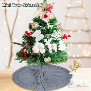 Close-up of a 24-inch grey knitted Christmas tree skirt with cable stitch and bow tie
