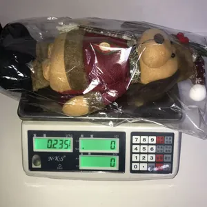 Detailed view of a plush Christmas doll on a scale showing a weight of 235 grams