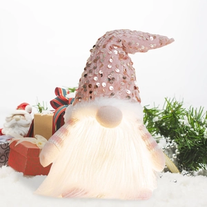 Close-up of glowing Christmas gnome with sequin hat and warm LED light in soft beard