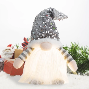 Macro shot of glowing Christmas gnome with sequin hat and warm LED light in beard