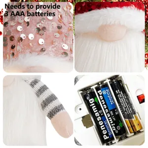 Lighted Christmas gnome plush with pink sequin hat and long beard on holiday background
