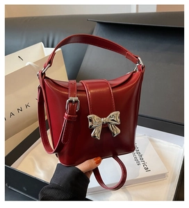 Détail du sac seau rouge avec boucle nœud argentée et bandoulière en cuir