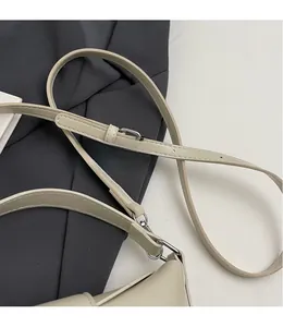 Détail de la bandoulière réglable crème avec boucle argentée et coutures précises