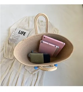 Top view of large straw tote bag showing spacious interior with tablet and wallet