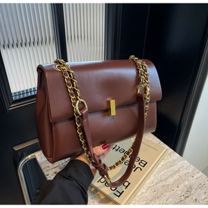 Dettaglio borsa a tracolla vintage marrone con catena dorata e chiusura in metallo