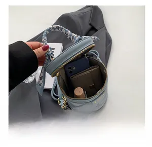 Détail intérieur du sac seau bleu matelassé avec espace pour téléphone et portefeuille