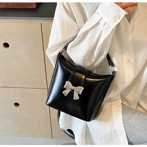 Vue détaillée du sac à main en cuir noir brillant avec un nœud métallique argenté chic