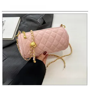 Detail of pink velvet cylinder bag with quilted pattern and gold chain strap
