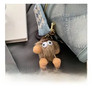 Gros plan d'un bijou de sac monstre en peluche marron avec ruban bleu et fermoir