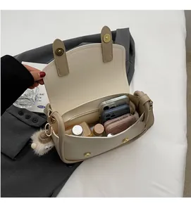 Detailed view showing the spacious interior of a beige faux leather saddle bag