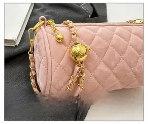 Detailed close-up of pink quilted cylinder bag with gold chain and metal ball adjuster
