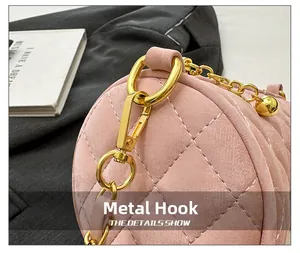 Close-up of golden metal hook and quilted pink cylinder bag with luxury chain strap