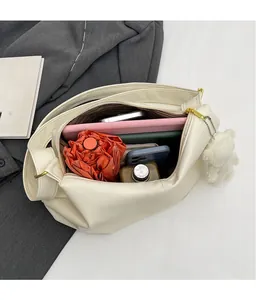 Detail view of large capacity cream shoulder bag with umbrella and tablet storage