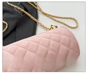 Close-up of pink quilted cylindrical bag showing fine stitching and metal chain detail