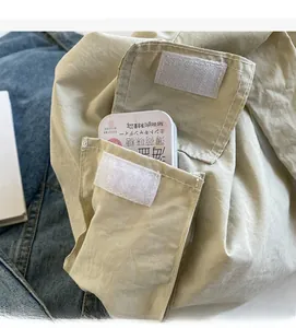 Détail d'un sac cabas en toile kaki avec une poche avant durable et fermeture velcro