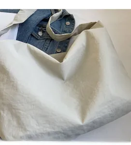 Gros plan détaillé d'un grand sac cabas beige en toile avec texture en tissu plissé doux