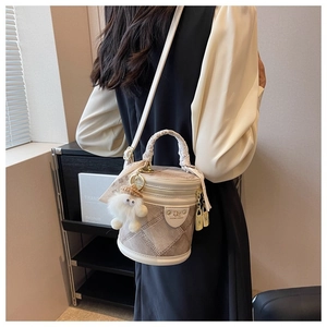 Détail du sac seau en toile beige avec patchwork cuir, anse tressée et breloque peluche