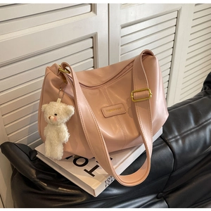 Detailed shot of pink PU leather tote with golden buckle and white bear charm