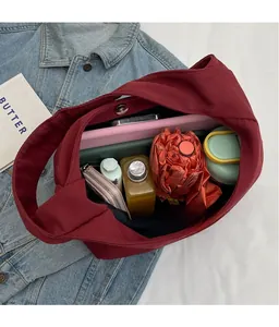 Spacious burgundy canvas tote bag showing interior storage capacity and magnetic snap closure
