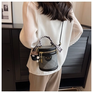 Détail du sac seau en denim gris avec bordure en cuir et foulard à carreaux sur bois