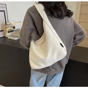 Detail view of large cream canvas tote bag with wide strap for daily commute use