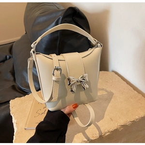 Détail du sac seau en cuir blanc crème avec boucle en métal et bandoulière réglable