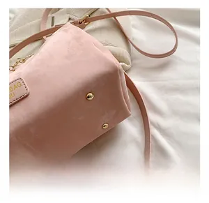 Close-up of pink Boston bag bottom with golden protective studs and fine hardware details