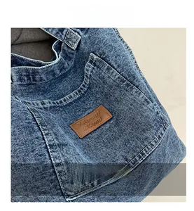 Detail of washed denim fabric with brown leather patch and embossed 7Street branding