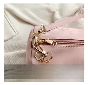 Macro shot of pink Boston bag showing gold floral charm and metallic hook detail