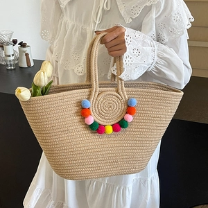Straw woven tote bag with colorful pom-pom charms for beach vacation and daily use